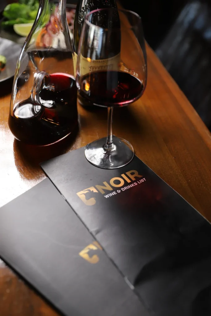 Noir wine list and red wine on the table